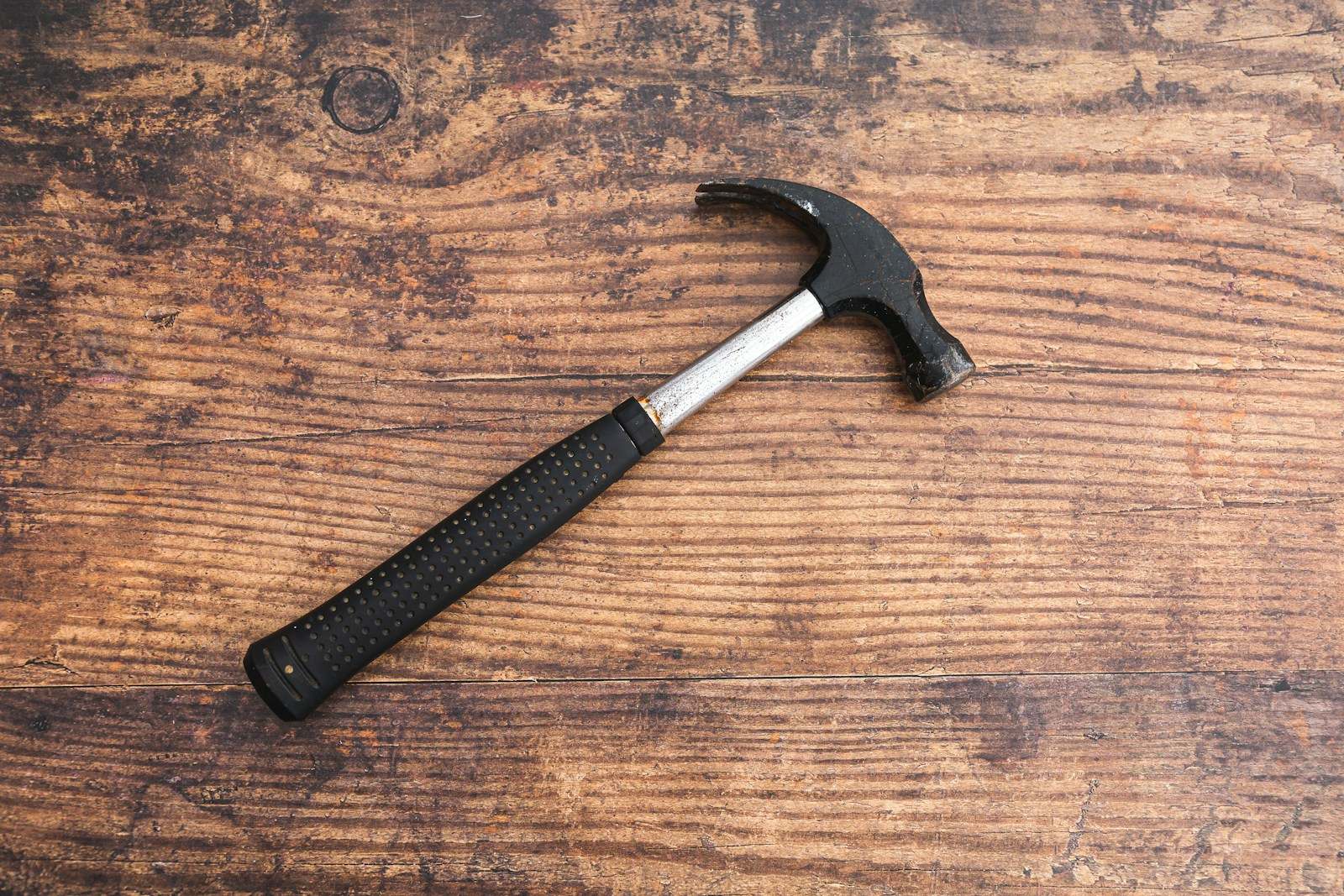 Claw hammer on a wooden workbench representing handyman repair work